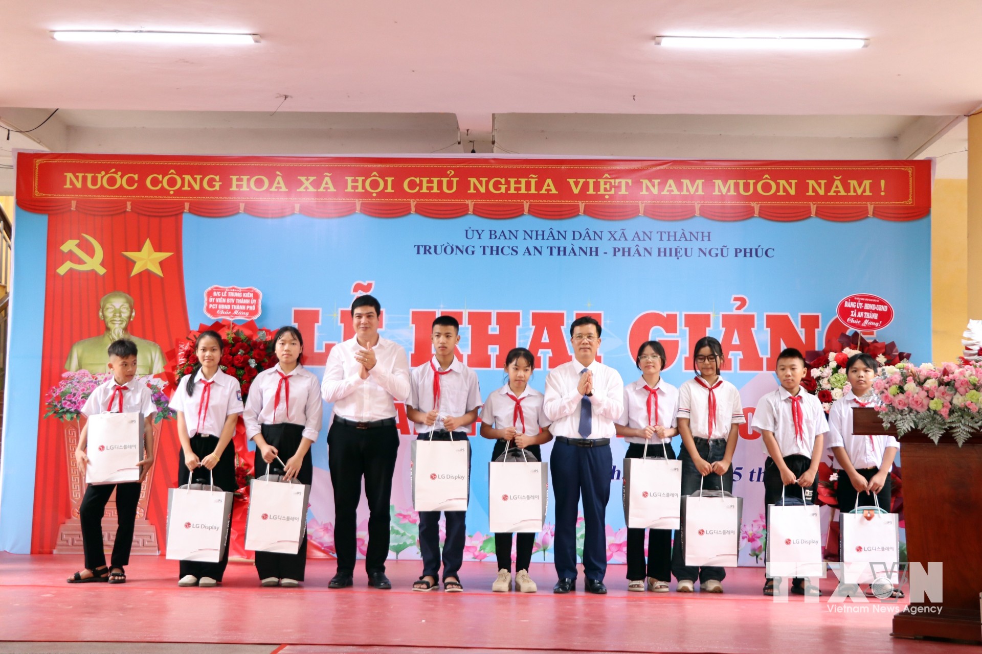 Lãnh đạo Ban Quản lý Khu kinh tế Hải Phòng và xã An Thành tặng quà cho học sinh Trường THCS An Thành có hoàn cảnh khó khăn. (Ảnh: Mạnh Tú/TTXVN)